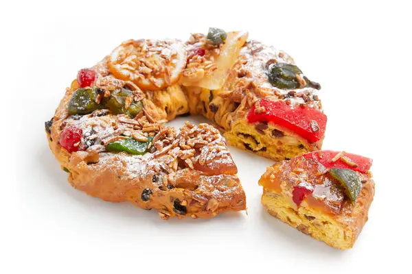 Kısmen dilimlenmiş bir çelenk şekerlemeli meyve, fındık ve pudra şekerli kek.