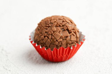 Tipik Brezilyalı tatlı tugadeiro. Beyaz arka planda kırmızı kağıt kalıplı kakao şekeri.