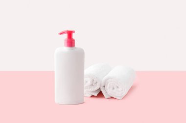 Pastel pembe ve beyaz arka planda bir şişe samimi hijyen jeli. Vücut bakımı güzellik tedavi konsepti. 