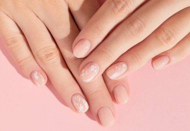 Güzel kadın elleri ve pembe arka planda çıplak tırnak tasarımı. Manikür, pedikür güzellik salonu konsepti. Yüksek kalite fotoğraf