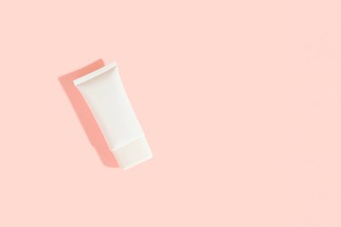 Pembe arka planda beyaz plastik kozmetik tüp. Kozmetik satış konsepti. Şablonu düzenle