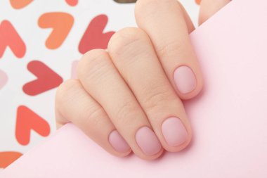 Modaya uygun pembe mat manikürlü kadın eli. Güzellik salonu. Tedavi spa vücut bakımı 