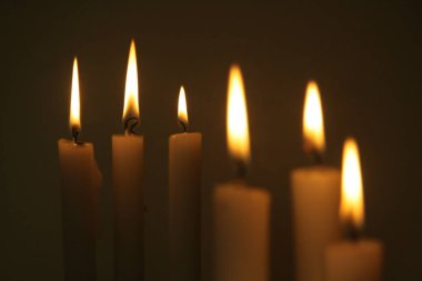 Composition of white candles in a dark and warm atmosphere