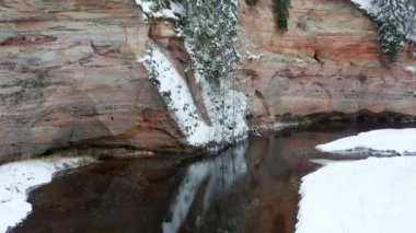 Aerial view of sandstone cliffs on the banks of Ahja river located at Taevaskoja, Estonia during a cold and snowy winter day
