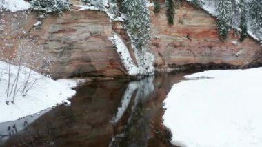 Aerial view of sandstone cliffs on the banks of Ahja river located at Taevaskoja, Estonia during a cold and snowy winter day