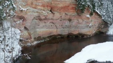 Aerial view of sandstone cliffs on the banks of Ahja river located at Taevaskoja, Estonia during a cold and snowy winter day