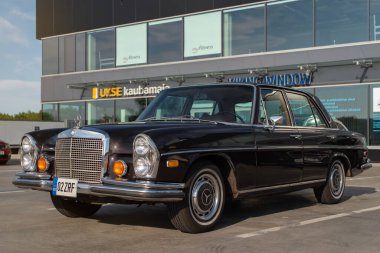 Tallinn, Estonya - 11 Temmuz 2023: Vintage Mercedes-Benz 280 SE 1970 Tallinn 'de güneşli bir yaz akşamı park edilmiştir. Modern şehir arka planında klasik araba. 