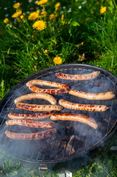 Izgara sosisli barbekü dışarıda sigara içiyor. Kömür Izgarasında Lezzetli Sosisli Barbekü.