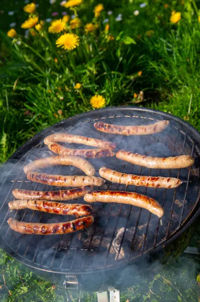 Açık Mangal Izgarası 'nda cızırdayan Sosisler. Smoky Bratwurst Sunny Backyard 'da Kömür Pişiriyor