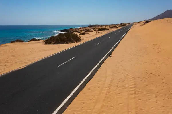 Fuerteventura 'nın Altın Sahilleri' ndeki Manzaralı Sahil Yolu. Turkuaz Atlantik Suları 'nın yanında Çöldeki Kumları Kesen Boş Yol
