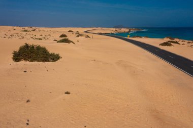 Fuerteventura 'nın Altın Sahilleri' ndeki Manzaralı Sahil Yolu. Turkuaz Atlantik Suları 'nın yanında Çöldeki Kumları Kesen Boş Yol