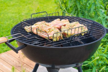 Arka bahçede ızgaraya hazır et ile barbekü. Mangal Kömürü Izgarası Kablo Sepetinde Mevsimlik Kesiklerle Dolu