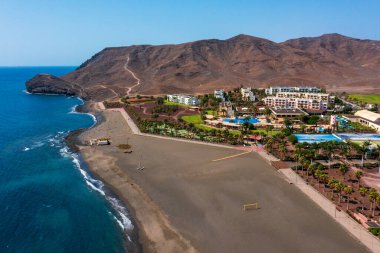 Las Playitas, Spain- October 14 2021: Las Playitas Resort: A Luxurious Oasis in Canary Islands. Aerial view of resort featuring a golf course, Olympic-sized pool, and breathtaking mountain backdrop. clipart