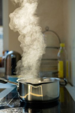 Mutfaktaki kaynama kabından buhar yükseliyor. Fırındaki Pişirme Sürecinin Kapanışı