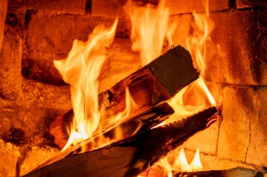 Geleneksel Tuğla Şöminede Yanan Kütükler Canlı Turuncu Alevler ve Dans Eden Ateşle. Konforlu Ev HEarth 'ün Yakın Çekim Fotoğrafı Kırsal Tuğlaya Karşı Ayrıntılı Ateş Şablonunu Gösteriyor