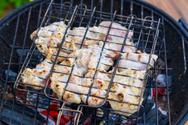 Kömür mangalında marine edilmiş tavuk göğsü ızgarası, yanında da Char Marks. Geleneksel Round Grill Grate 'de Altın Kahverengi Kabuklu Sulu Tavuk