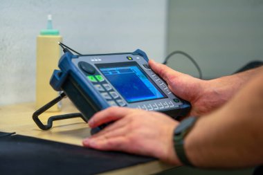 Ultrasonik Test Ekipmanı. NDT Endüstriyel Ayarlar Müfettişi. Kalite denetimi için dijital ekranı olan gelişmiş NDT aygıtını yapılandıran profesyonel teknisyen