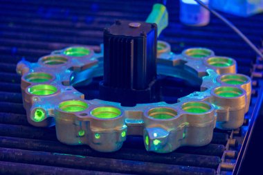 Havacılık NDT Teftişi flüoresan fren testini gösteriyor. UV aydınlatması, kalite kontrol sırasında uçak fren pistonu konutlarında yüzey sürekliliğinin bozulduğunu ortaya çıkarır