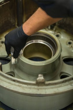 Uçak Tekerleği NDT Teftişi Ultrasonik Test Malzemeleri Kullanılıyor. Havacılık bakım teknisyeni iniş takımları bileşenini zararsız bir şekilde test ediyor.
