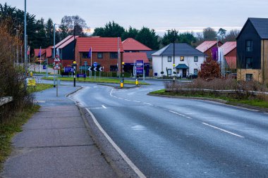 Takeley, UK - December 07, 2024: Modern Housing Development in Takeley, Essex During Winter Evening. Typical British Suburban Street Scene with Mixed Architecture and Red Roofs in Residential Area clipart