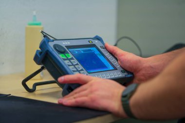 Endüstriyel NDT Müfettişi Kalite Kontrol için Ultrasonik Test Malzemeleri Kuruyor. Zararsız Malzeme Denetlemesi için Taşınabilir UT Aygıtı Yapılandıran Teknisyen