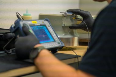Endüstriyel NDT Müfettişi Kalite Kontrol için Ultrasonik Test Malzemeleri Kuruyor. Zararsız Malzeme Denetlemesi için Taşınabilir UT Aygıtı Yapılandıran Teknisyen