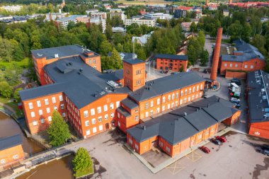 Forssa, Finlandiya - 20 Ağustos 2021: Forssa, Finlandiya 'daki tarihi kırmızı tuğla sanayi kompleksinin havadan görünüşü. Eski tekstil fabrikası binaları şehrin kültürel mirasının bir parçası olarak yeniden tasarlandı.