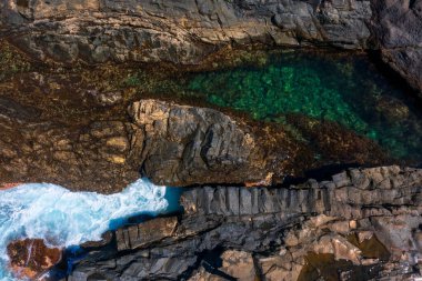 Aguas Verdes, Fuerteventura 'daki volkanik kayalarda gizli zümrüt havuzu. Okyanus dalgaları engebeli kıyı şeridine çarparak büyüleyici bir gelgit havuzu oluşturuyor.