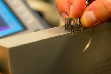 NDT Laboratuvarındaki Referans Bloğunda Ultrasonik Test Kalibrasyon Süreci. UT dönüştürücü ayarlarını hassas teftiş için ayarlayan teknisyenlere yakın çekim