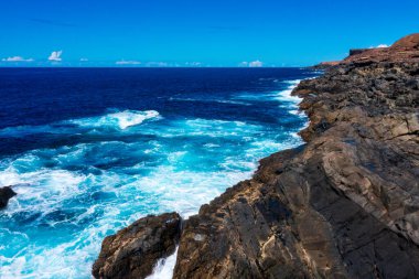 Fuerteventura 'nın çarpıcı kıyı manzarası. Karanlık Volkanik Uçurumlara Karşı Kırılan Turkuaz Dalgalar. Kanarya Adalarından Dramatik Okyanus Manzarası