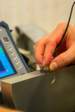 NDT Laboratuvarındaki Referans Bloğunda Ultrasonik Test Kalibrasyon Süreci. UT dönüştürücü ayarlarını hassas teftiş için ayarlayan teknisyenlere yakın çekim