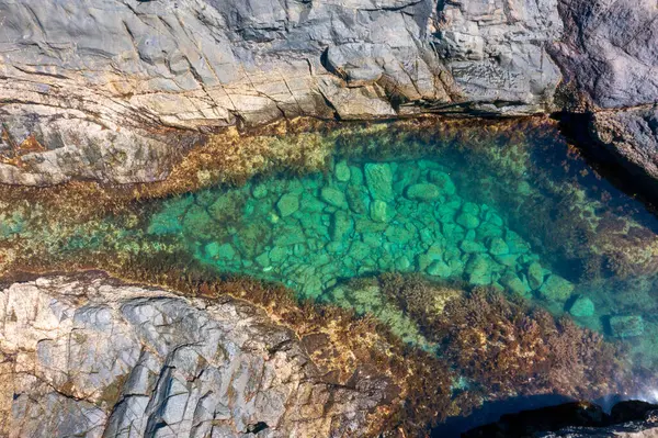 Aguas Verdes, Fuerteventura 'daki volkanik kayalarda gizli zümrüt havuzu. Okyanus dalgaları engebeli kıyı şeridine çarparak büyüleyici bir gelgit havuzu oluşturuyor.