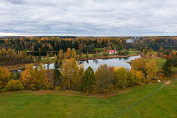 Serene Gölü ve Renkli Orman ile Sonbahar Manzarası. Altın Ağaçlar, Yeşil Tarlalar ve Huzurlu Lakefront 'lu Dramatik Bulutlu Gökyüzü Sonbahar Ülkesi