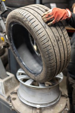 Otomotiv Lastik Değiştirme Servisi Garaj Atölyesinde Profesyonel Lastik Bağlama Makinesi ile. Mevsimsel Lastik Değiştirme Süreci için Mekanik Eller Uzmanlaşmış Ekipman