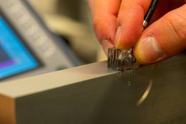 NDT Laboratuvarındaki Referans Bloğunda Ultrasonik Test Kalibrasyon Süreci. UT dönüştürücü ayarlarını hassas teftiş için ayarlayan teknisyenlere yakın çekim