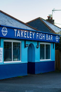 Takeley, İngiltere - 7 Aralık 2024: Essex 'te mavi kaplamalı geleneksel İngiliz balık ve patates kızartması dükkanı. Takeley Balık Çubuğu, turkuaz ve lacivert renkli, klasik tabelalı bir renge sahiptir.