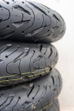 Spor lastik desenli ve hassas mühendislik detaylarına sahip motorsiklet lastiklerinin yakın çekimi. Yeni siyah motosiklet lastiği gelişmiş kavrama teknolojisi ve performans odaklı yiv tasarımı sergiliyor