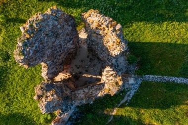 Laiuse Kalesi 'nin havadan görünüşü canlı yeşil çimlerle çevrili antik taş temelleri gösteriyor. Bu tepeden tırnağa İHA perspektifi, ortaçağ Estonya kalesinin tarihsel planını gözler önüne seriyor.