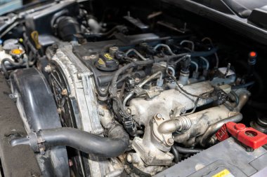 Modern Araç Motoru Detaylı Mekanik Bileşenleri ve Sistemleri Gösteriyor. Görünür hortumları, vanaları ve çalışma koşullarında kabloları olan otomotiv içten yanmalı güç santrali.