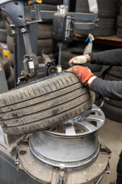 Otomotiv Lastik Değiştirme Servisi Garaj Atölyesinde Profesyonel Lastik Bağlama Makinesi ile. Mevsimsel Lastik Değiştirme Süreci için Mekanik Eller Uzmanlaşmış Ekipman
