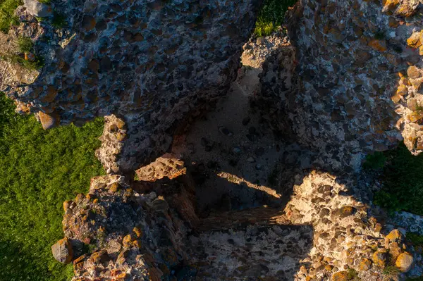 Laiuse Kalesi 'nin havadan görünüşü canlı yeşil çimlerle çevrili antik taş temelleri gösteriyor. Bu tepeden tırnağa İHA perspektifi, ortaçağ Estonya kalesinin tarihsel planını gözler önüne seriyor.