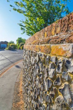 Geleneksel taş ve tuğla duvar inşaatı Norwich 'teki İngiliz inşaat tekniklerini gösteriyor. Yıpranmış dokusu ve kırsal yol boyunca büyüyen liken ile tarihi taş ustası.