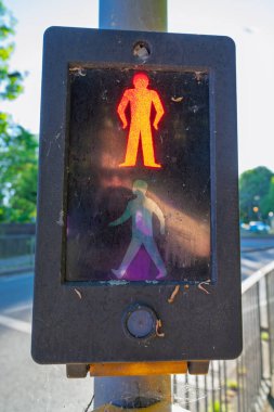 Bir İngiliz yaya geçidi işareti kırmızı bir dur figürü ve yıpranmış bir trafik ışığında yürüyen yeşil bir adam gösteriyor. Birleşik Krallık cadde geçiş kontrol aygıtı bekleme ve yürüme sembolleri görüntüler