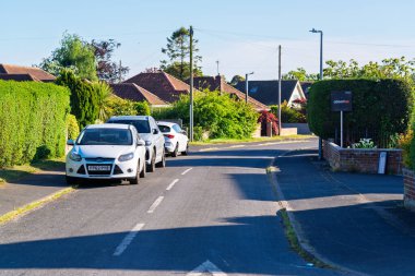 Norwich, UK- 17 Mayıs 2025: Park halindeki arabaları ve Norwich, İngiltere 'nin banliyö semtindeki güvenli arazileri olan sakin bir yerleşim yeri. Modern araçlar evlerle dolu huzurlu bir yolda park halindedir..