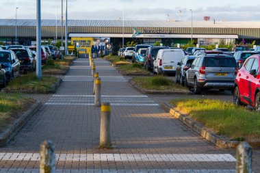 Norwich, UK- 17 Mayıs 2025 Norwich havaalanı otoparkı Terminal binasının girişindeki araçlarla dolu. Kaldırımlı kaldırımları ve organize park alanları olan İngiltere bölgesel havaalanı otoparkı.