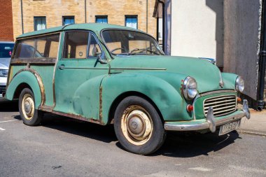 Norwich, UK- 17 Mayıs 2025 Norwich Caddesi 'nde üstü açık yeşil Morris Minor marka üstü açık araba. 1950 'lerin klasik İngiliz arabası otantik yıpranmış durumu ve çekiciliği sergiliyor.