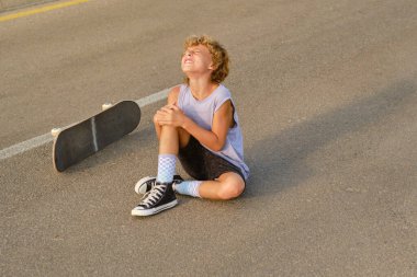 Yaralı dizini kucaklayan ve kaykaydan düştükten sonra acı çeken çocuk yüksek açılı.