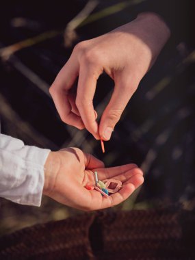 Anonim bir kadının güneş ışığında ergen bir çocuğun eline attığı plastik çöpten.