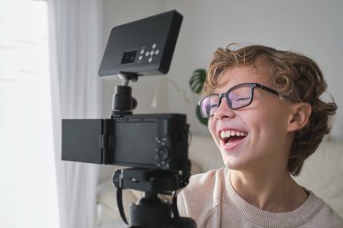 Evde blog yazarken kameraya kapalı gülümseyen komik çocuk