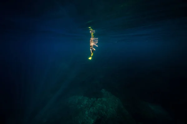 바다의 어두운 파란색 아래에서 노란색 플리퍼에 인식할 다이버 — 스톡 사진